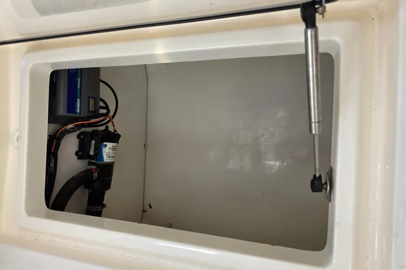 Slide: The Image of 2003 Boston Whaler 255 Conquest storage compartment with pump and wiring. - 33