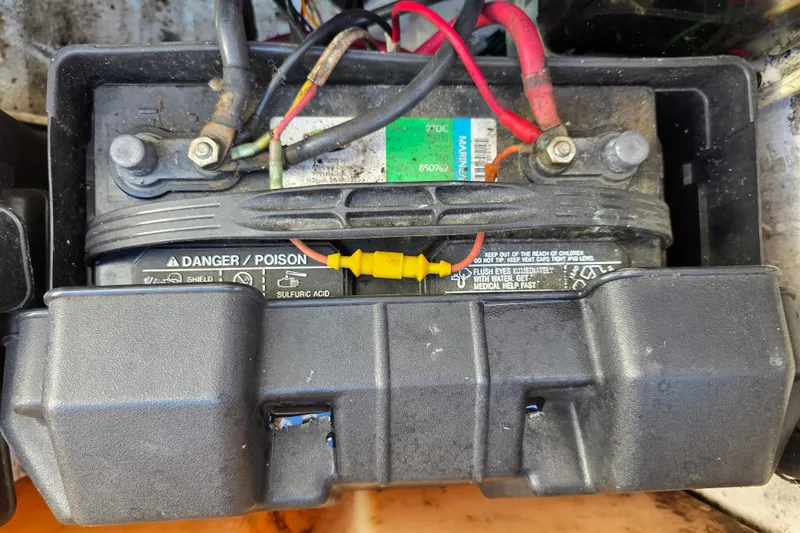 Slide: The Image of Battery compartment of a 2003 Boston Whaler 255 Conquest boat, showing wiring and safety labels. - 36