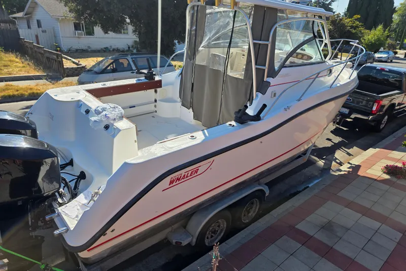 Slide: The Image of 2003 Boston Whaler 255 Conquest boat on trailer, parked on a residential street. - 4