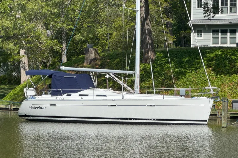 The Image of 2002 Beneteau Oceanis 393 sailboat docked by lush greenery. - 0