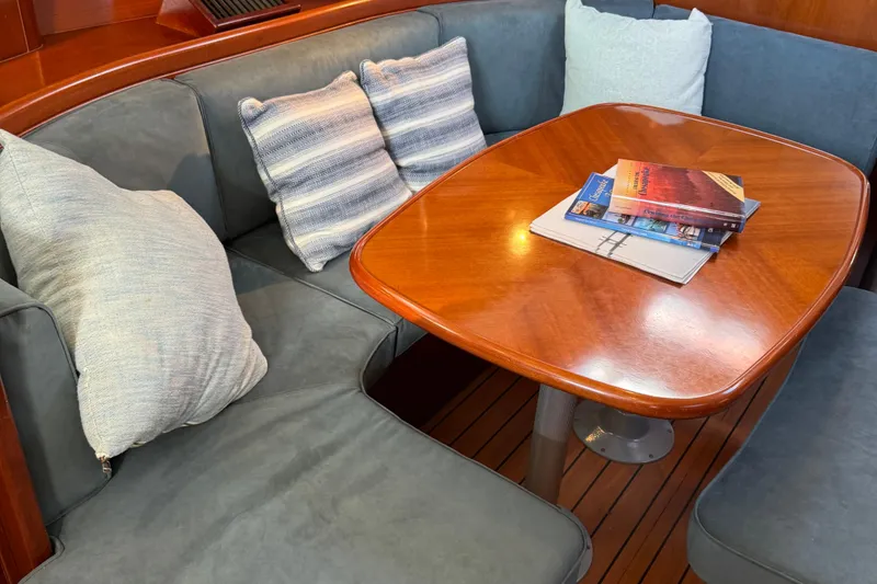 Slide: The Image of Cozy interior of 2002 Beneteau Oceanis 393 with cushioned seating and wooden table. - 4