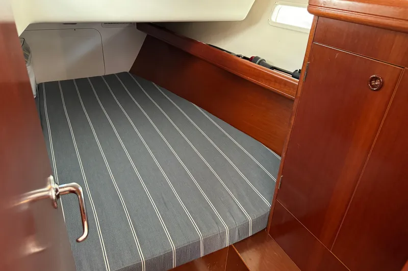 Slide: The Image of Cozy cabin interior of 2002 Beneteau Oceanis 393 sailboat with striped bedding. - 6