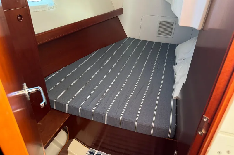Slide: The Image of Cozy cabin interior of 2002 Beneteau Oceanis 393 with striped bedding. - 7