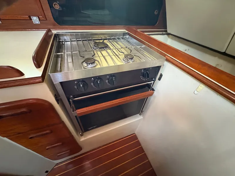 Slide: The Image of Galley stove in 1984 Irwin 41 sailboat, featuring a stainless steel finish and wooden accents. - 12