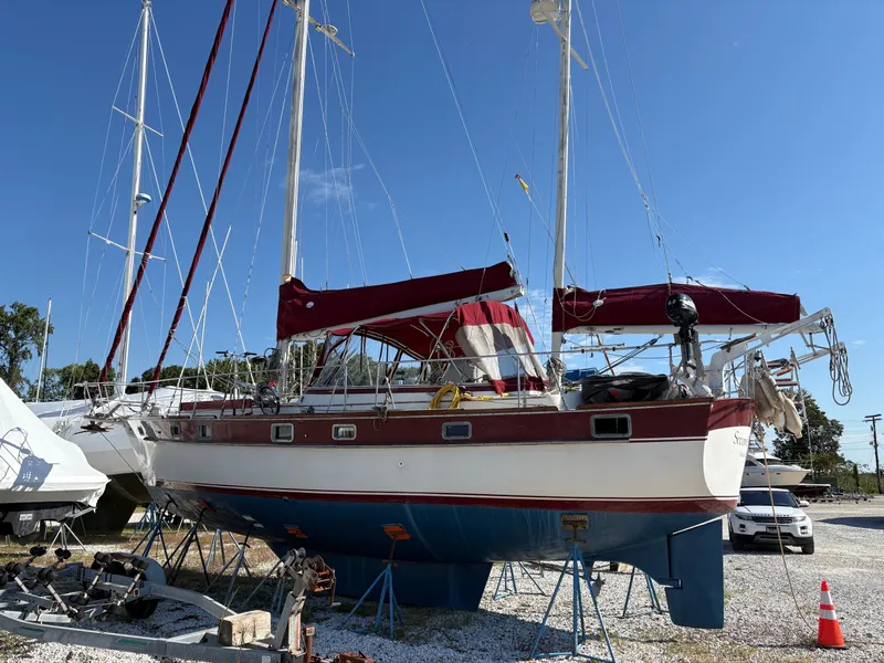 Slide: The Image of 1984 Irwin 41 sailboat on stands, red and white hull, clear blue sky background. - 2