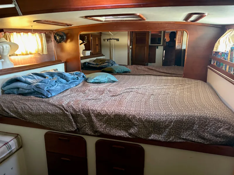 Slide: The Image of Cozy bedroom interior of 1984 Irwin 41 sailboat with wooden accents and patterned bedding. - 22