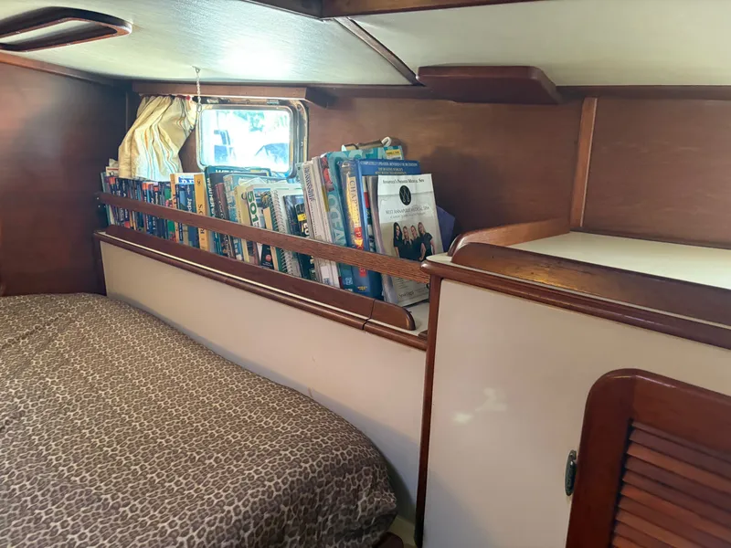 Slide: The Image of Cozy cabin interior of 1984 Irwin 41 sailboat with books and leopard print bedding. - 24