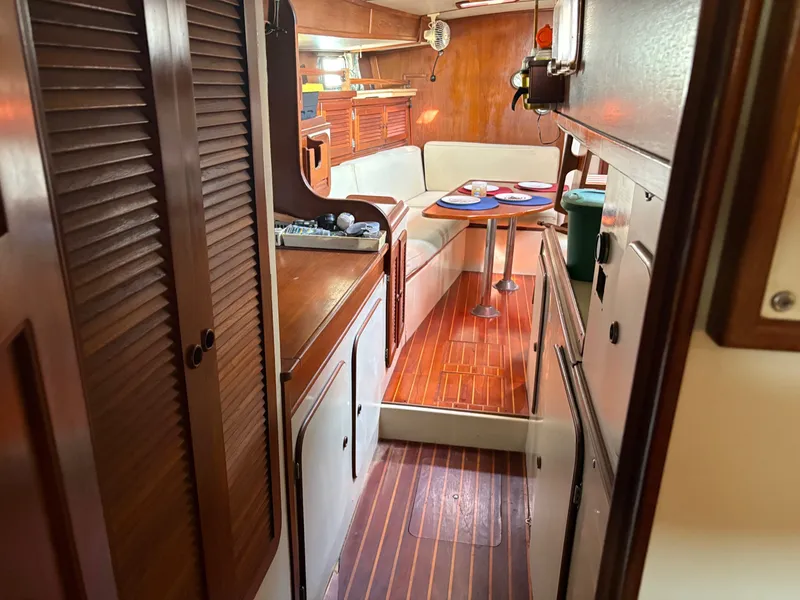 Slide: The Image of Interior of 1984 Irwin 41 sailboat with wooden flooring and cozy dining area. - 28
