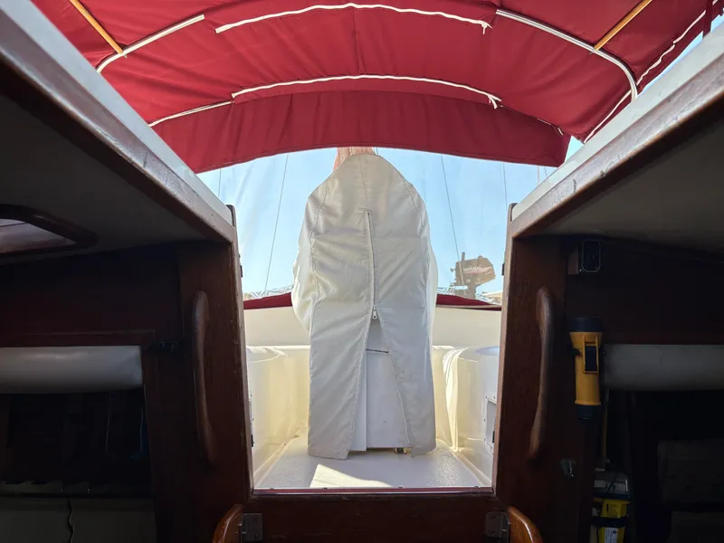 Slide: The Image of Interior view of a 1984 Irwin 41 sailboat with red canopy and white seating. - 30