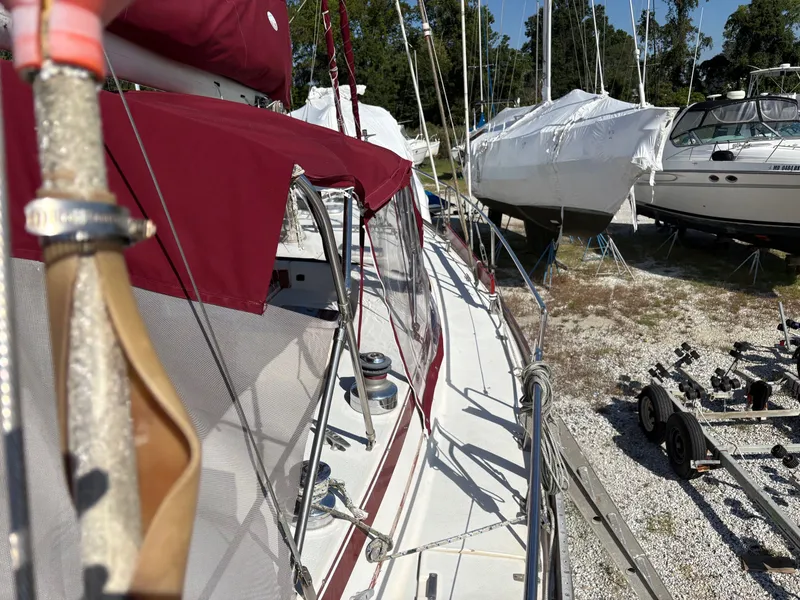 Slide: The Image of 1984 Irwin 41 sailboat with maroon covers, docked alongside other boats. - 6