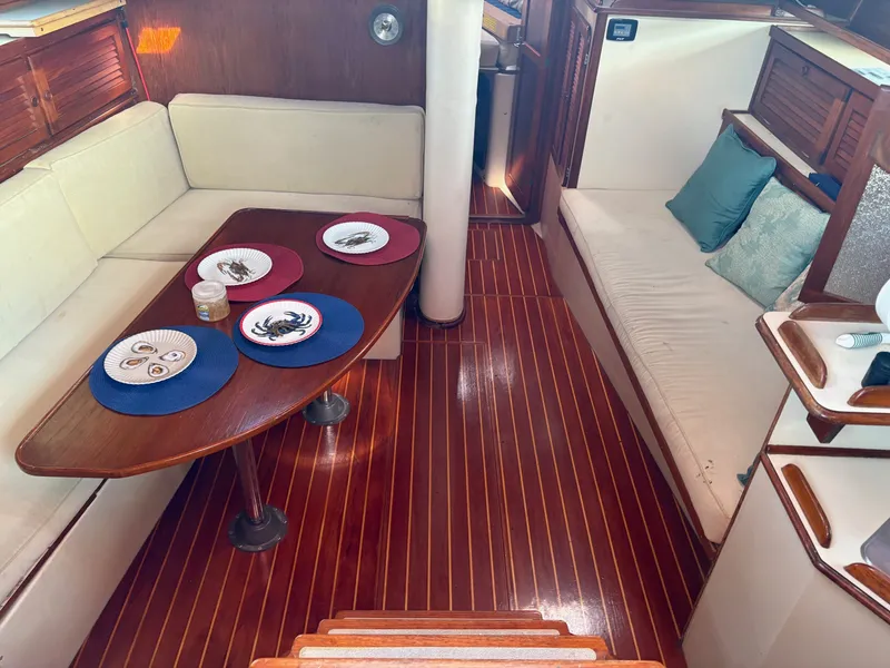 Slide: The Image of Interior of 1984 Irwin 41 sailboat with wooden flooring and cozy seating area. - 9