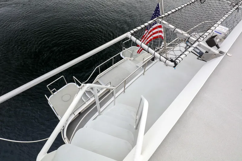 Slide: The Image of 2007 MetalCraft Catamaran deck with American flag and safety netting over water. - 13