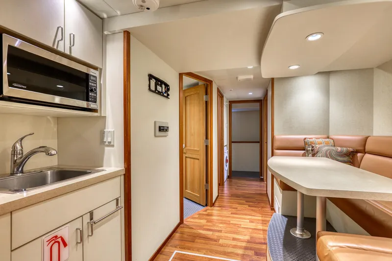 Slide: The Image of Modern 2007 MetalCraft Catamaran interior with kitchenette, dining area, and wood flooring. - 26