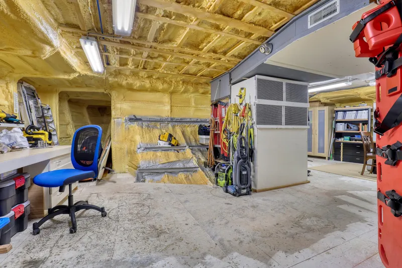 Slide: The Image of Workshop interior on a 2007 MetalCraft Catamaran, featuring tools, storage, and a blue chair. - 36