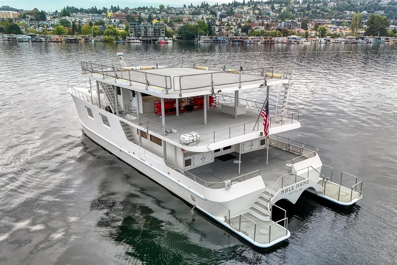 Slide: The Image of 2007 MetalCraft Catamaran on calm water, featuring spacious deck and American flag. - 4