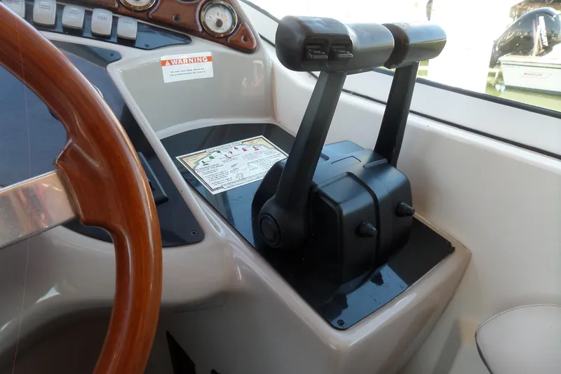Slide: The Image of 2003 Doral 280 SE boat cockpit with steering wheel and throttle controls. - 25