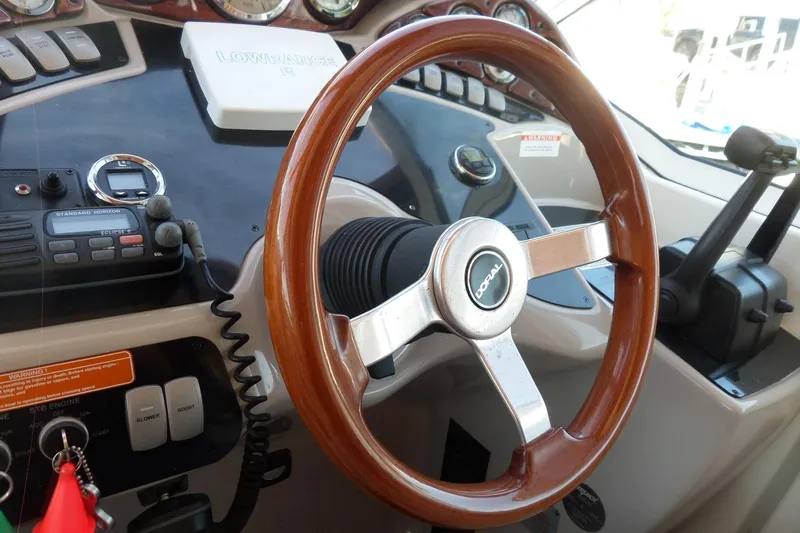 Slide: The Image of 2003 Doral 280 SE boat dashboard with wooden steering wheel and control panel. - 26