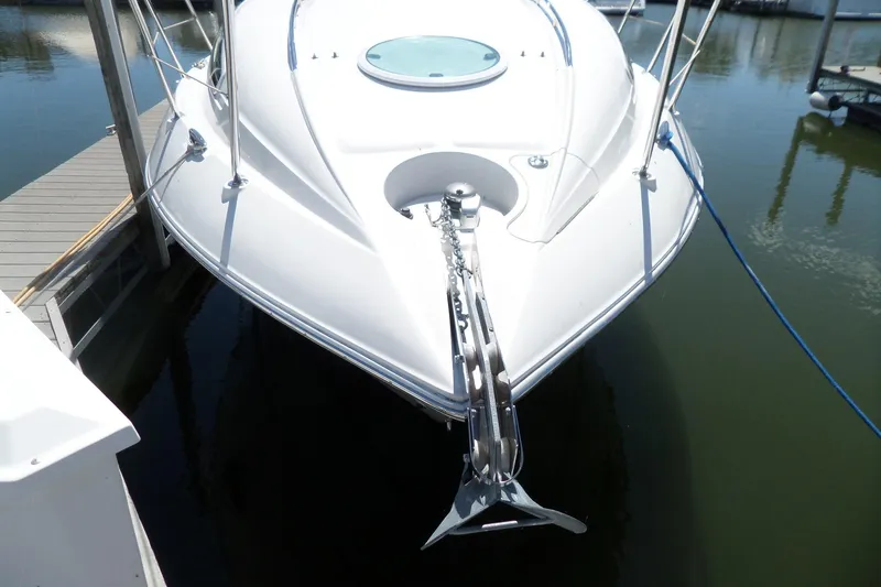 Slide: The Image of 2003 Doral 280 SE boat docked, showcasing sleek bow design and anchor. - 3
