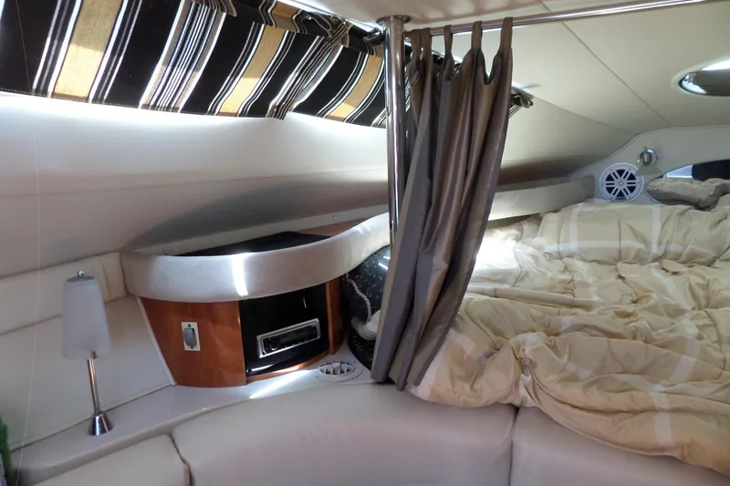 Slide: The Image of Interior cabin of a 2003 Doral 280 SE boat with bed and striped curtains. - 31