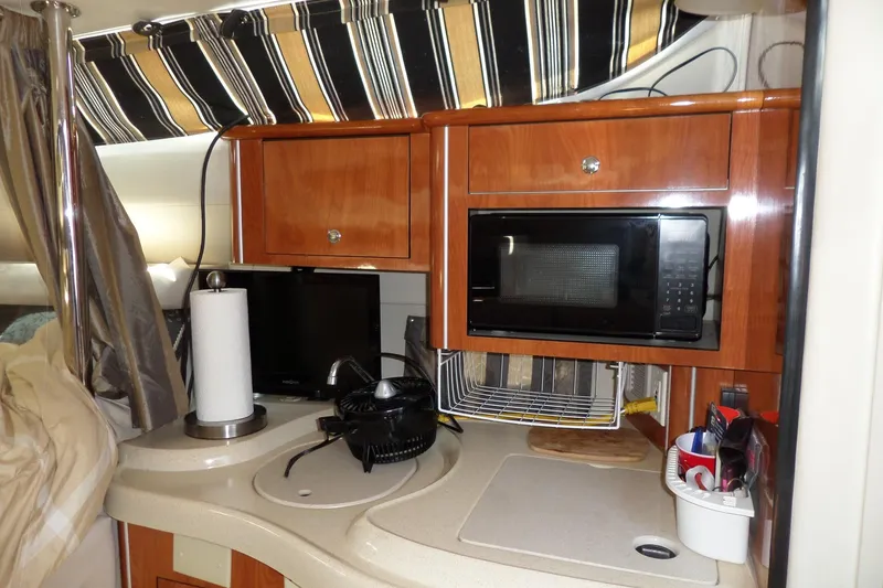 Slide: The Image of Interior of 2003 Doral 280 SE boat with kitchenette, microwave, and storage cabinets. - 34