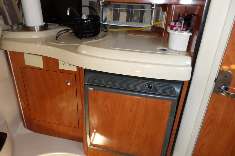 Slide: The Image of 2003 Doral 280 SE boat kitchenette with wood cabinets and compact appliances. - 35