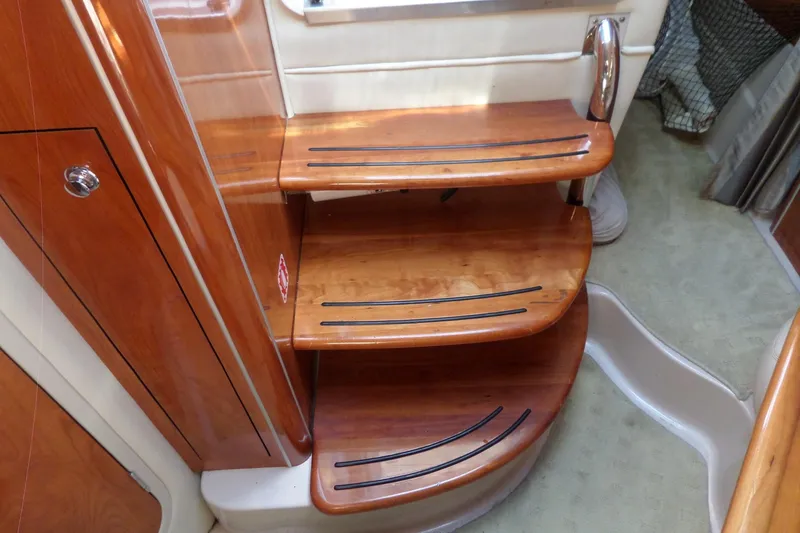 Slide: The Image of Wooden interior stairs of a 2003 Doral 280 SE boat, featuring sleek design and non-slip strips. - 42
