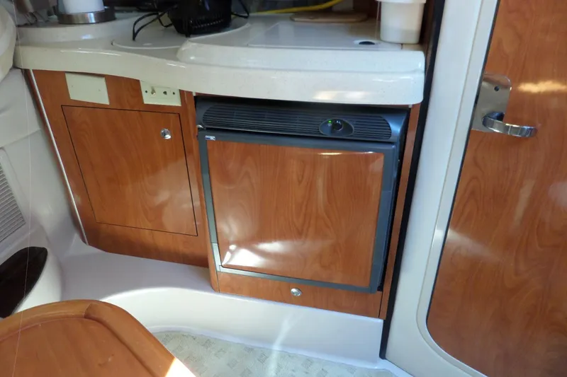 Slide: The Image of Interior of a 2003 Doral 280 SE boat featuring a compact kitchenette. - 46