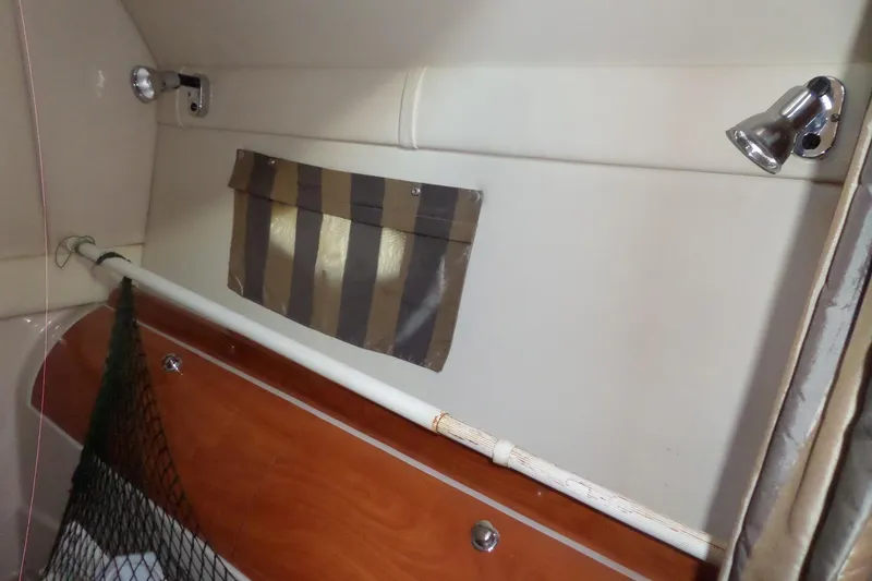 Slide: The Image of Interior of 2003 Doral 280 SE boat with striped pocket and wooden paneling. - 54