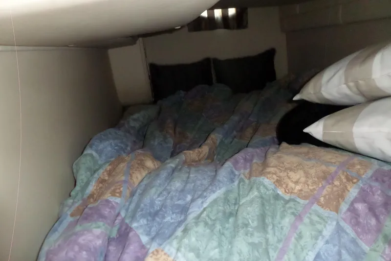 Slide: The Image of Cozy cabin bed inside a 2003 Doral 280 SE boat, with colorful bedding and pillows. - 56