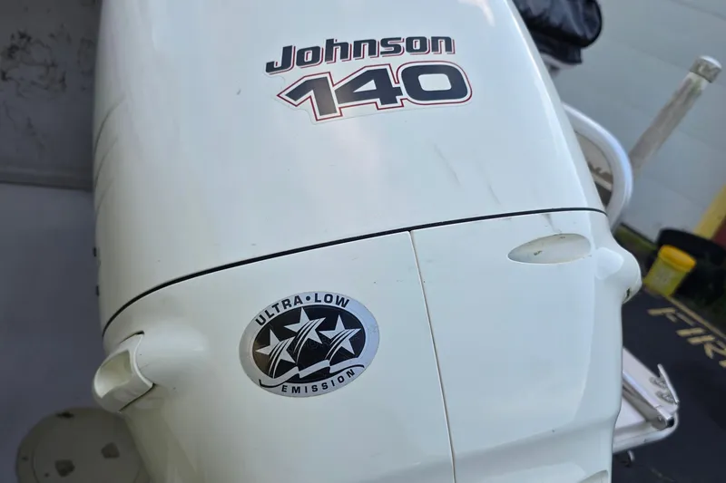 Slide: The Image of Johnson 140 outboard motor with ultra-low emission sticker, on a 2003 Hurricane 226R boat. - 14