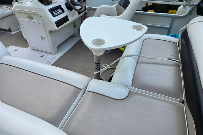 Slide: The Image of Interior of a 2003 Hurricane 226R boat with seating and a small table. - 15