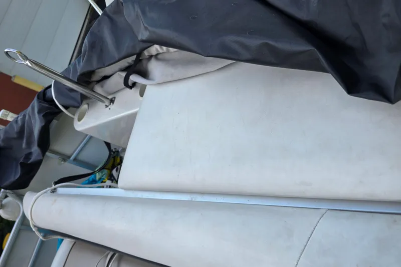 Slide: The Image of 2003 Hurricane 226R boat with protective cover, showing deck and railing details. - 16