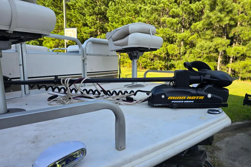 Slide: The Image of 2003 Hurricane 226R boat with Minn Kota PowerDrive motor on deck, surrounded by trees. - 2