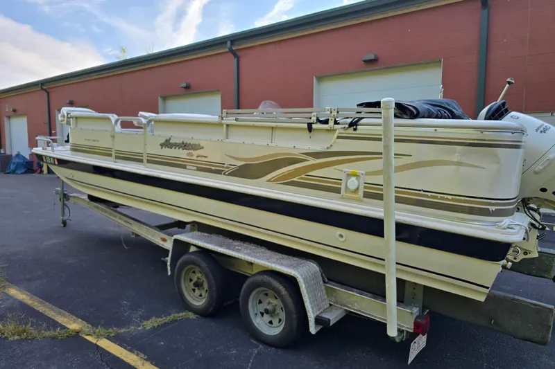 Slide: The Image of 2003 Hurricane 226R boat on trailer, parked near a building. - 3