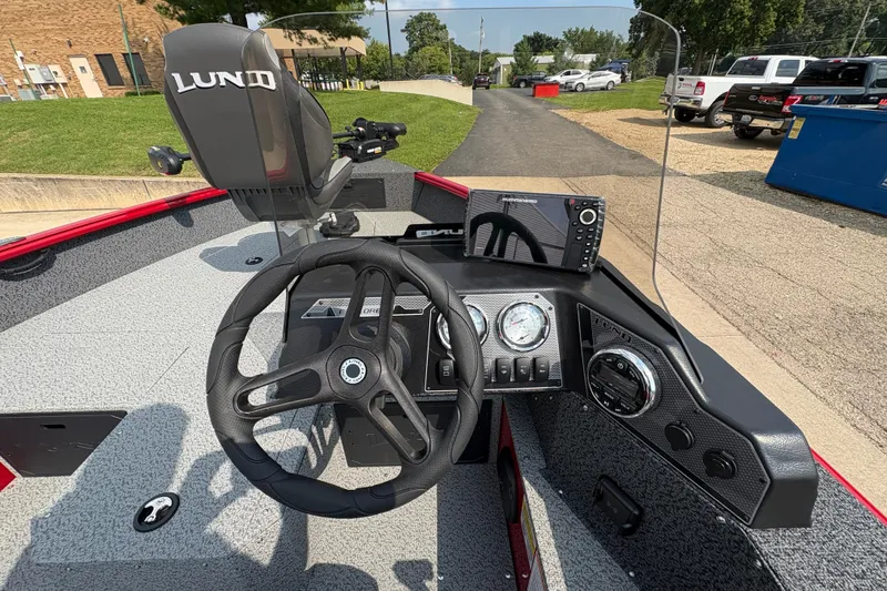 Slide: The Image of 2026 Lund 1800 Explorer SS boat dashboard with steering wheel and navigation system. - 19