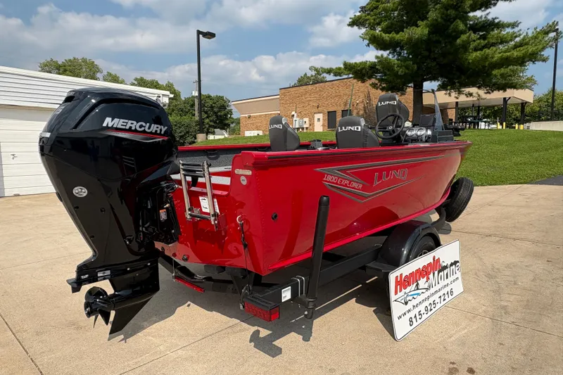 Slide: The Image of 2026 Lund 1800 Explorer SS boat with Mercury engine, displayed outdoors. - 2