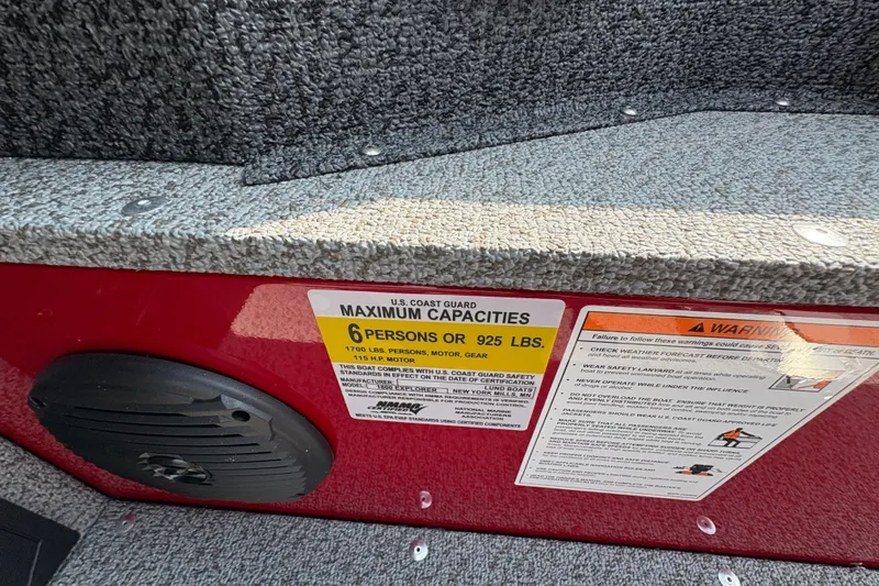Slide: The Image of 2026 Lund 1800 Explorer SS boat capacity label, 6 persons or 925 lbs, safety warnings visible. - 21