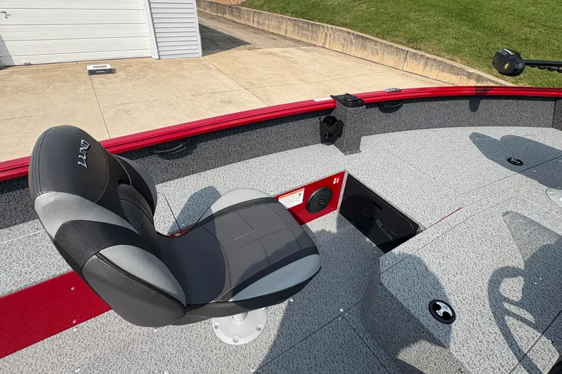 Slide: The Image of 2026 Lund 1800 Explorer SS boat interior with gray seating and red accents. - 22