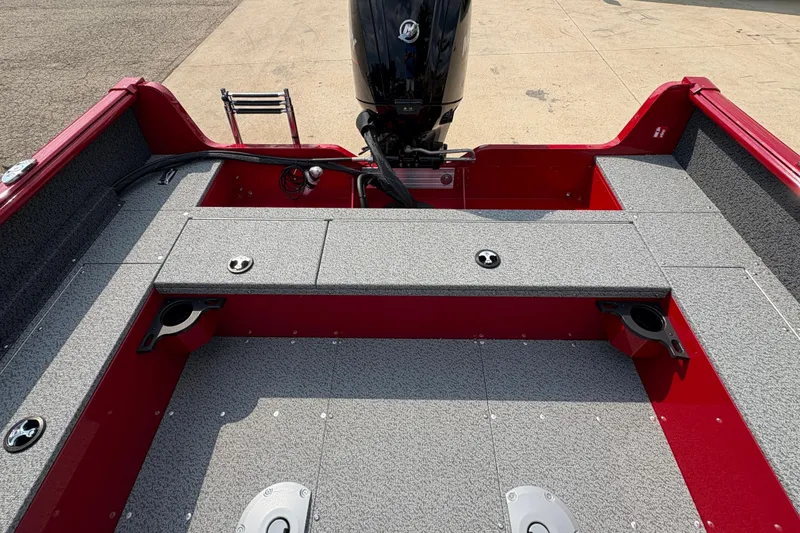 Slide: The Image of 2026 Lund 1800 Explorer SS boat interior with red and gray design, featuring motor and seating. - 25
