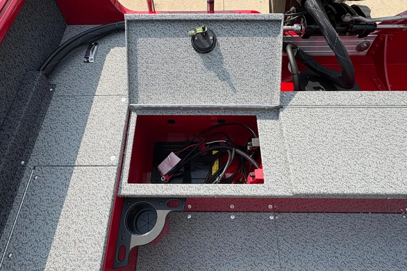Slide: The Image of Open storage compartment in 2026 Lund 1800 Explorer SS boat, showing wiring and battery. - 28