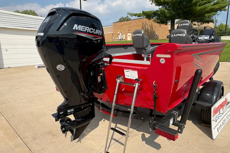 Slide: The Image of 2026 Lund 1800 Explorer SS boat with Mercury outboard motor, parked on a trailer. - 31