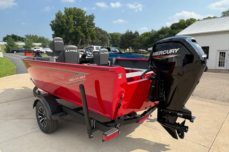 Slide: The Image of 2026 Lund 1800 Explorer SS boat with Mercury engine, parked outdoors on a sunny day. - 4