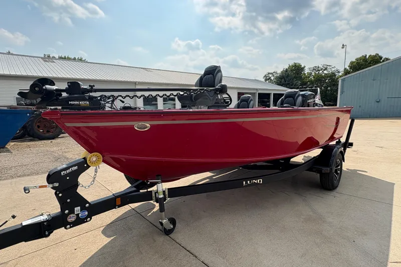 Slide: The Image of 2026 Lund 1800 Explorer SS boat in vibrant red on a trailer, outdoor setting. - 6