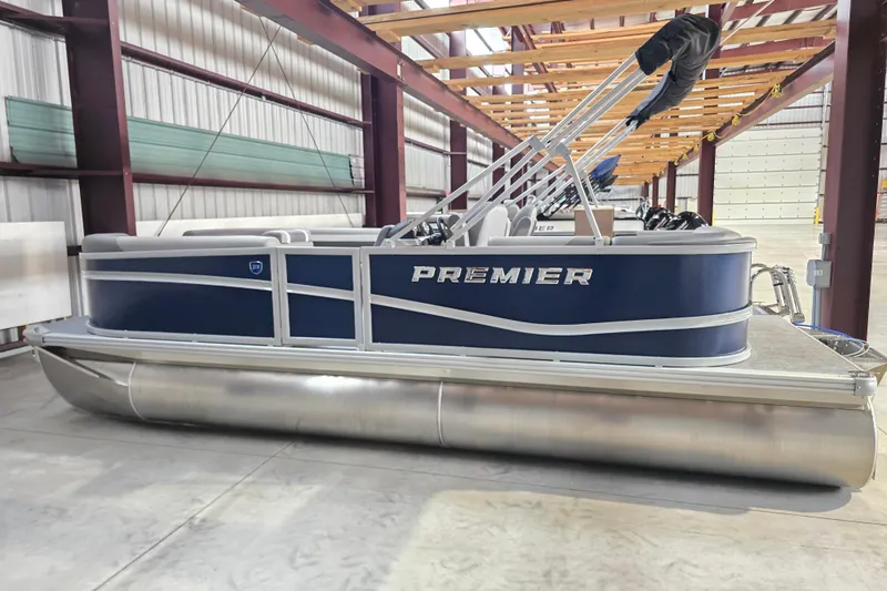 The Image of 2026 Premier 200 Sunscape pontoon boat parked outside a large green warehouse. - 0