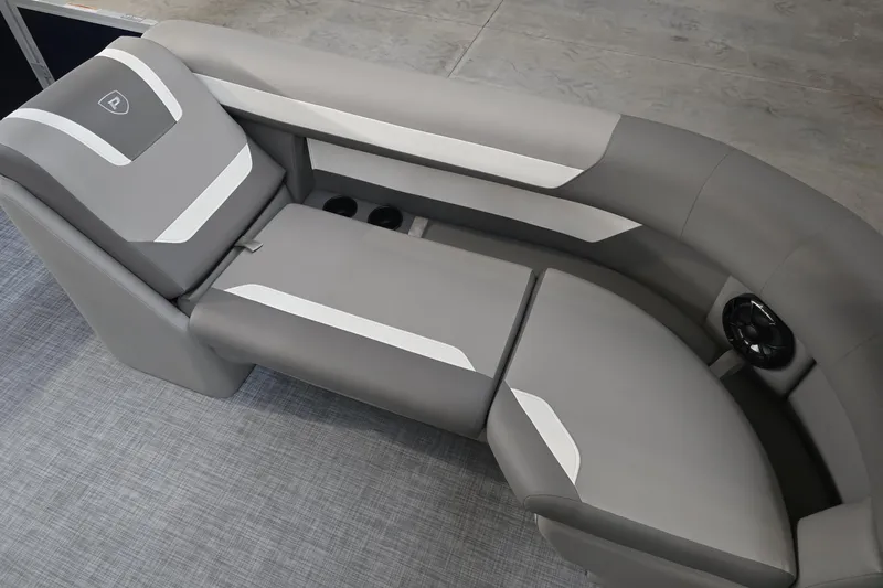 Slide: The Image of 2025 Premier 200 Sunscape boat interior with gray and white seating, cup holders, and speaker. - 27