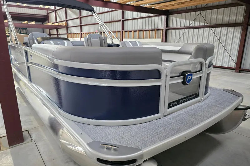 Slide: The Image of 2026 Premier 200 Sunscape pontoon boat with chrome ladder and blue paneling. - 6