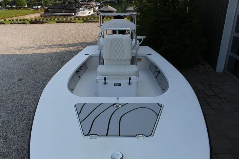 Slide: The Image of 2026 Delta D18 boat with white seating and storage, docked near a marina. - 5