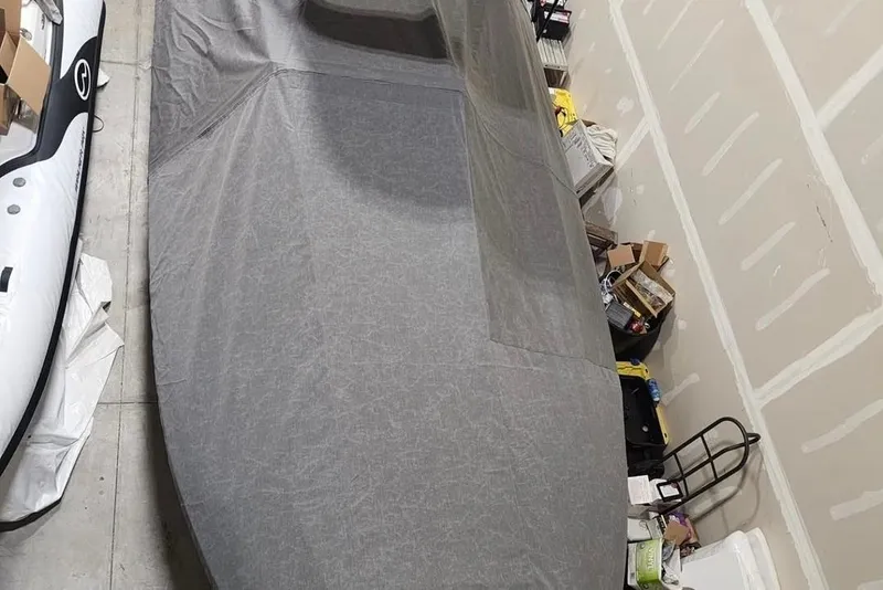 Slide: The Image of 2023 Walker Bay WB 22 boat covered in a garage with storage items nearby. - 5