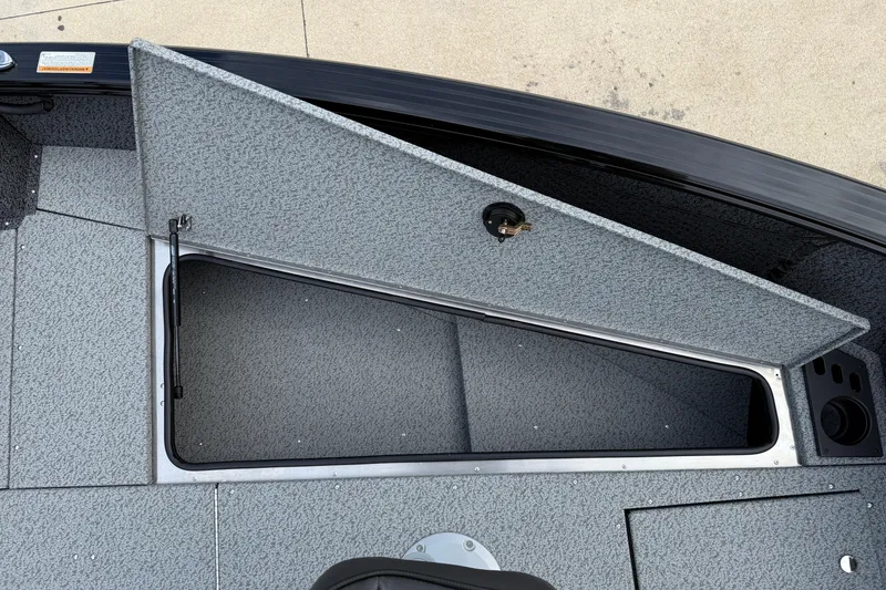 Slide: The Image of Open storage compartment on 2026 Lund 2075 Impact XS boat, featuring textured interior. - 11