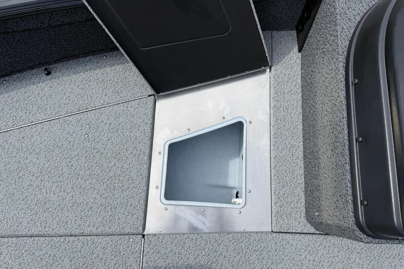 Slide: The Image of 2026 Lund 2075 Impact XS boat interior with storage compartment, gray carpeted flooring. - 14